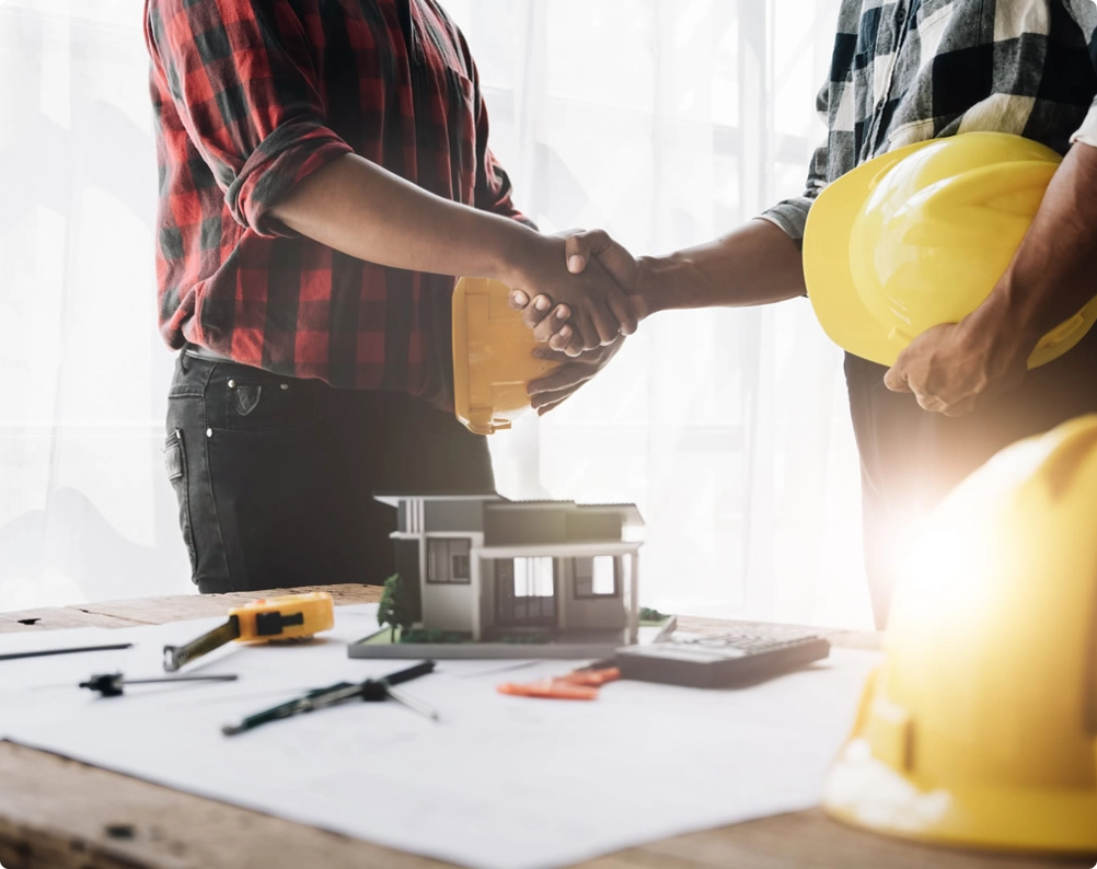 Contractors shaking hands over house plans